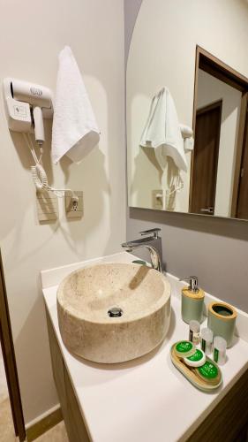 a bathroom with a stone sink on a counter at Jungle Guardian - Rooftop Pool & Beach Club in Zona Hotelera Tulum in Tulum