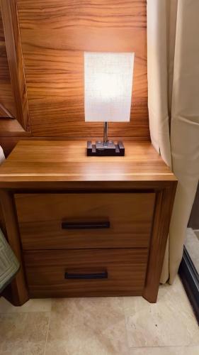 a nightstand with a lamp on it next to a bed at Jungle Guardian - Rooftop Pool & Beach Club in Zona Hotelera Tulum in Tulum