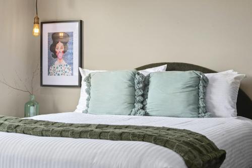 a bedroom with a large bed with white sheets and pillows at Evies Cottage I Belmont Suites I regionalXscapes in Belmont