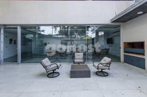 a group of chairs sitting in front of a building at Comfy Villa Morra Apt in Asuncion