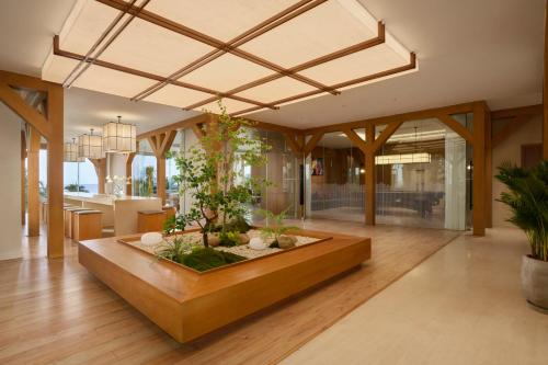 a living room with a table with plants in it at Signature by M Village Beachfront Hotel in Da Nang
