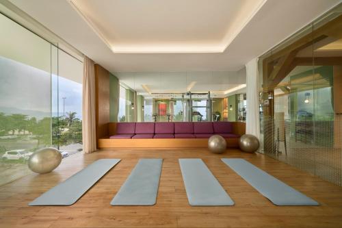 a living room with a purple couch and yoga mats at Signature by M Village Beachfront Hotel in Da Nang