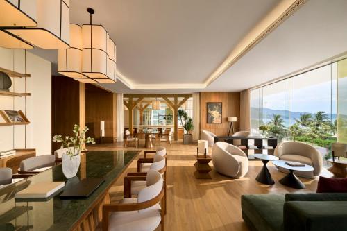 a living room with a table and chairs at Signature by M Village Beachfront Hotel in Da Nang
