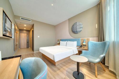 a hotel room with a bed and a desk and a chair at Home Inn Neo Zhuji Zhejiang Agriculture and Forestry University in Shaoxing