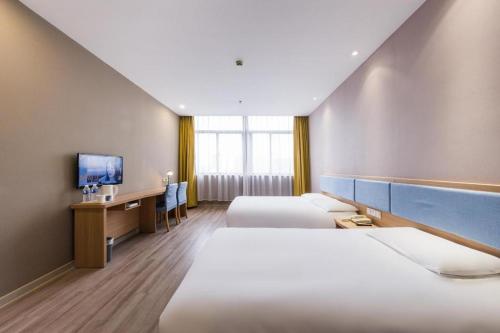 a hotel room with two beds and a desk and a tv at Home Inn Neo Zhuji Zhejiang Agriculture and Forestry University in Shaoxing