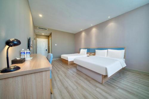 a hotel room with a bed and a desk at Home Inn Neo Zhuji Zhejiang Agriculture and Forestry University in Shaoxing