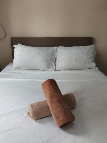 a white bed with two towels on it at Simple Stay Perfect for Restful Nights in Molo