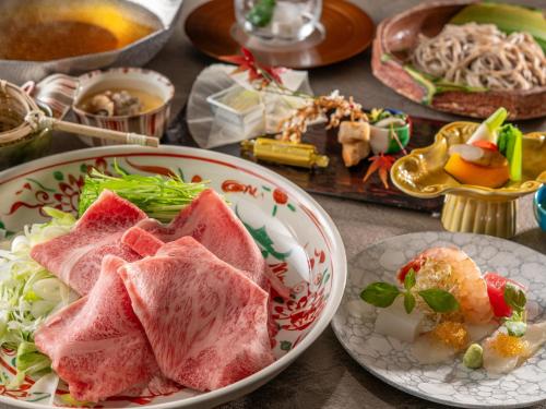 a table with two plates of food on it at KAMENOI HOTEL Ome in Ome