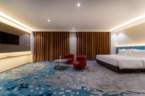 a hotel room with a bed and a table and chairs at The Skye Phnom Penh Hotel & Apartments in Phnom Penh