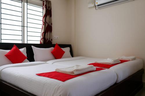 two beds with red and white towels on them at Dreamzz Comforts in Chikmagalūr