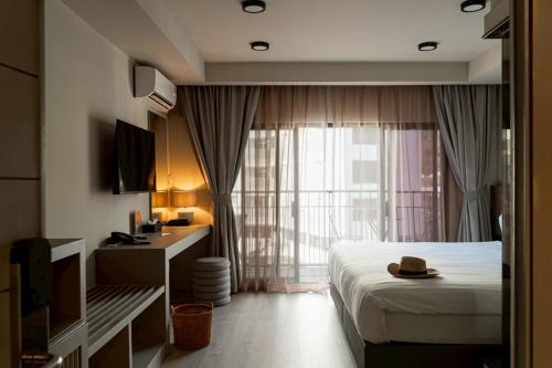 a hotel room with a bed and a window at Karon Boutique in Karon Beach