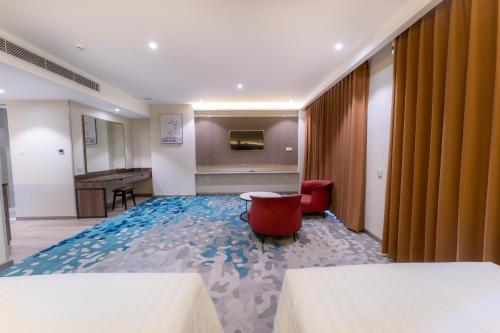 a hotel room with two beds and a television at The Skye Phnom Penh Hotel & Apartments in Phnom Penh