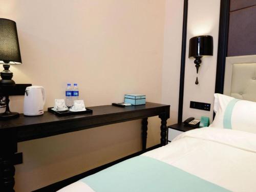 a hotel room with a bed and a desk with two beds at Xana Hotelle Xi'an Zhonglou, Huimin Street Metro Station in Xi'an