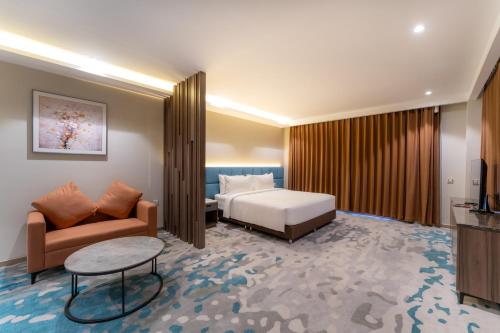 a hotel room with a bed and a couch at The Skye Phnom Penh Hotel & Apartments in Phnom Penh