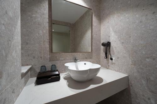 a bathroom with a bowl sink and a mirror at The Skye Phnom Penh Hotel & Apartments in Phnom Penh