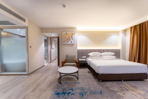 a hotel room with two beds and a table at The Skye Phnom Penh Hotel & Apartments in Phnom Penh