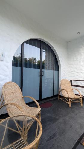 two chairs and a glass table in front of a building at Hakuna Matata Arugambay in Arugam Bay