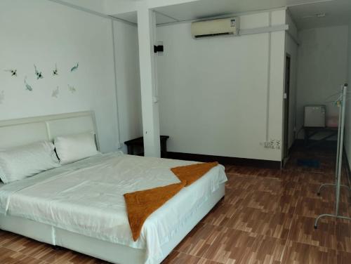 a bedroom with a white bed and a wooden floor at Waterfall Guesthouse1 in Phumĭ Kaôh Rŏng