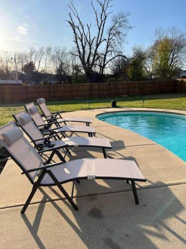 a row of lounge chairs next to a swimming pool at Oasis Of Nashville, With A Pool And Hot Tub ! in Nashville