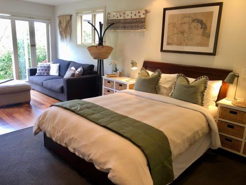 a bedroom with a large bed and a living room at Sweet As Suite in Auckland