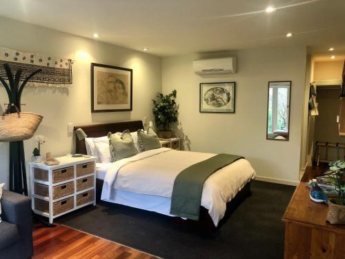 a bedroom with a bed and a dresser in it at Sweet As Suite in Auckland