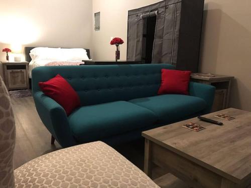 a blue couch with red pillows in a living room at North Valley Studio - Near Balloon Fiesta Park in Albuquerque