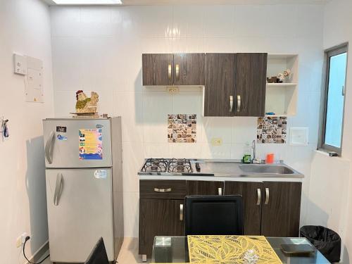 a kitchen with a refrigerator and a sink at Apartamento la Isla 1-Coveñas in Coveñas