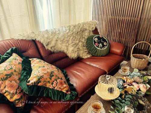 a brown leather couch sitting in a living room at chichinpuipui house2 in Kirishima