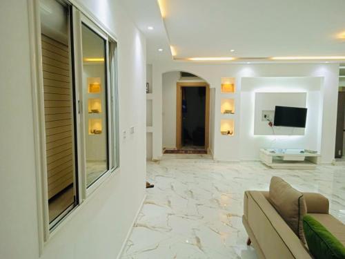 a living room with a couch and a flat screen tv at Villa Sounine Rafraf in Bizerte