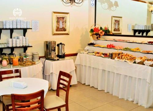 a restaurant with two tables and a buffet of food at Hotel Marbella in Punta del Este