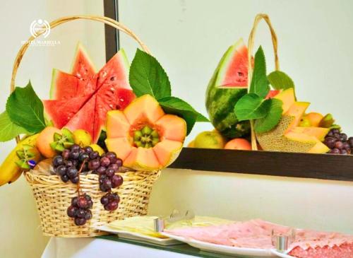 a basket of fruit on a table with a plate at Hotel Marbella in Punta del Este