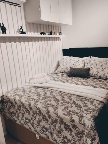 a large bed in a bedroom with a white wall at Loft 132 Industrial luxury in Mogi das Cruzes