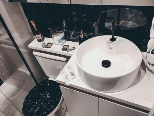 a bathroom with a white sink and a toilet at Loft 132 Industrial luxury in Mogi das Cruzes