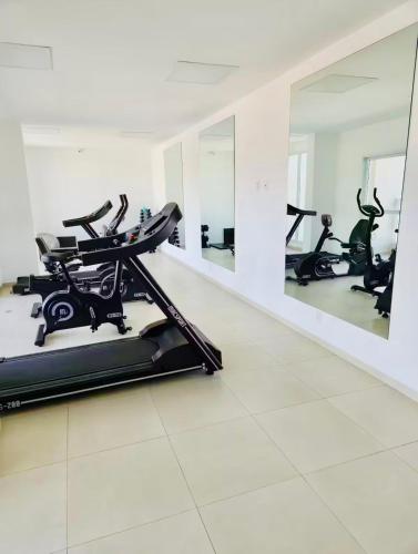 a gym with several treadmills and mirrors at Loft 132 Industrial luxury in Mogi das Cruzes
