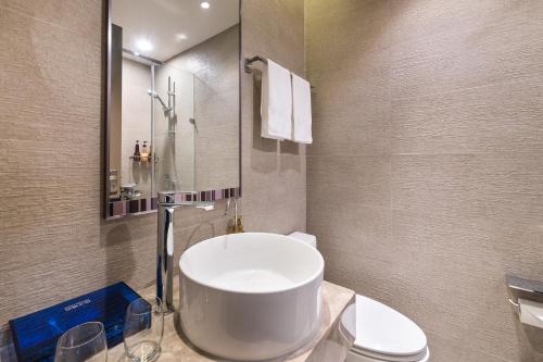 a bathroom with a large white sink and a toilet at Orange Hotel Beijing Temple of Heaven North Gate in Beijing