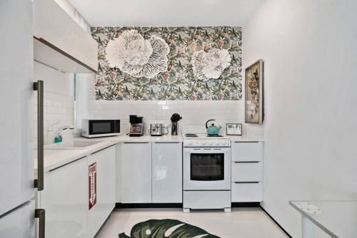 a kitchen with white appliances and a wallpaper at Las Olas Hammocks Unit 3 By Pmi in Fort Lauderdale