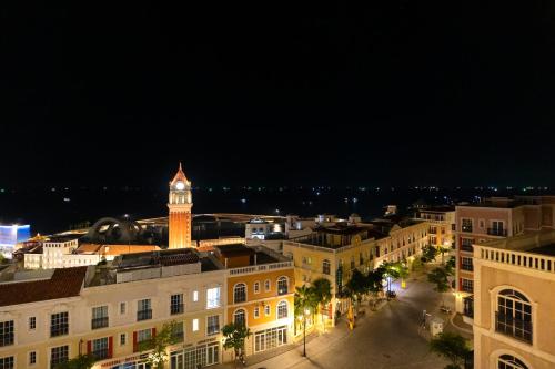 a view of a city at night with a clock tower at The Hill Apartment - Phú Quốc - Firework & Ocean View in Phu Quoc
