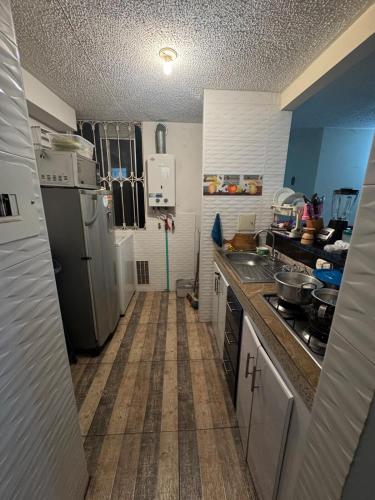 a small kitchen with a sink and a refrigerator at Double bedroom TV cabinet in Soacha