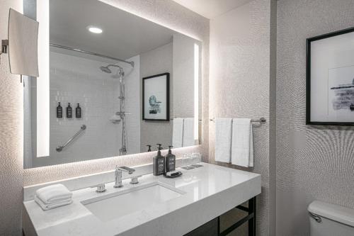 a bathroom with a sink and a large mirror at Sheraton LaGuardia East Hotel in Queens
