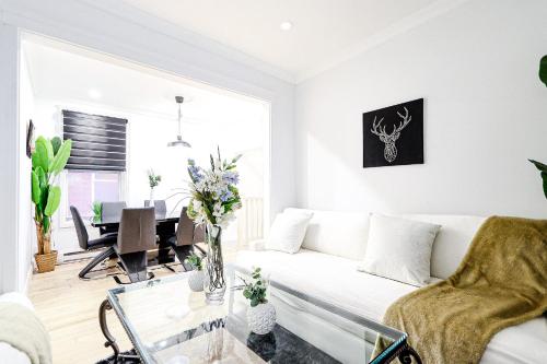a living room with a white couch and a table at Royal Level-5 bedrooms avec 2 places de parking in Montréal