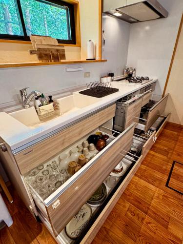a kitchen with an open drawer with dishes in it at Moyai House in Hakuba