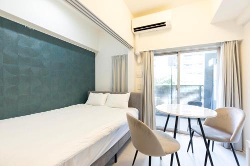 a bedroom with a bed and a table and chairs at Star Residence2 春吉中洲 in Fukuoka