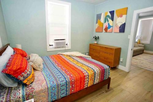 a bedroom with a bed and a dresser and a window at BOHO Vibes! Walk 2 Beach & Ocean Center! in Daytona Beach