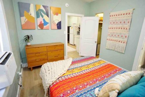 a bedroom with a bed and a wooden dresser at BOHO Vibes! Walk 2 Beach & Ocean Center! in Daytona Beach