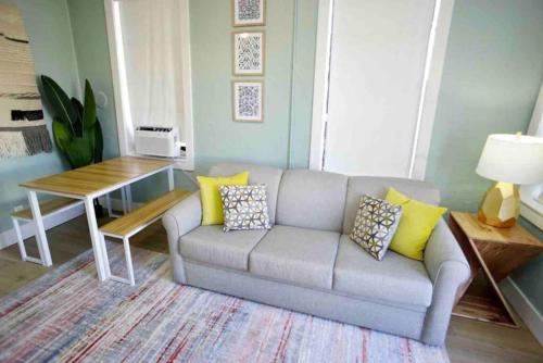 a living room with a couch and a table at BOHO Vibes! Walk 2 Beach & Ocean Center! in Daytona Beach