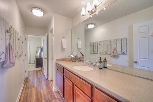 a bathroom with a sink and a large mirror at Riverfront Retreat-Near Broadway, Pool, Park Free in Nashville