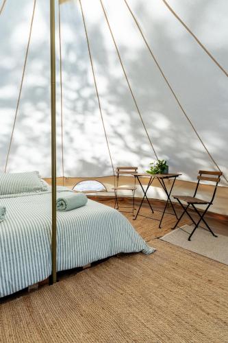 a bedroom with a bed and a table and chairs at Glamping by the beach in Hanko