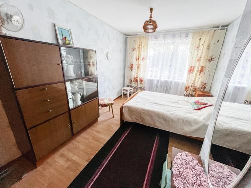 a small bedroom with a bed and a dresser at Cozy Seaside Apartment in Lahemaa in Loksa
