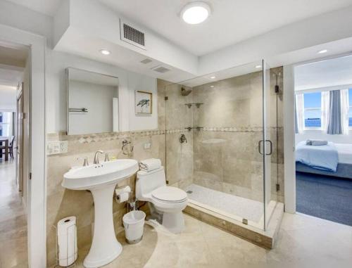 a bathroom with a toilet and a shower and a sink at Luxury Beachfront Condo By Pmi in Fort Lauderdale
