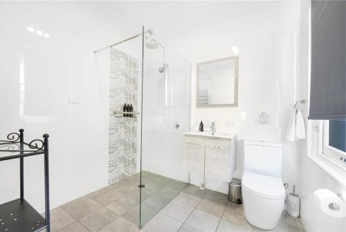 a white bathroom with a toilet and a shower at Blue Door Apartment - CBD Location, 2 Bed 2 Bath in Orange